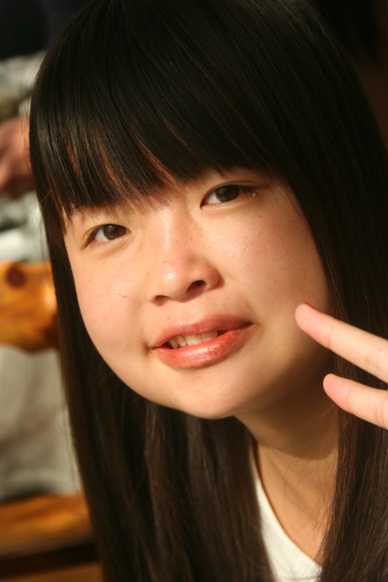 an asian girl in front of her hand up