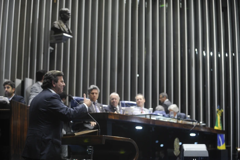 a man is giving a speech while in front of several people