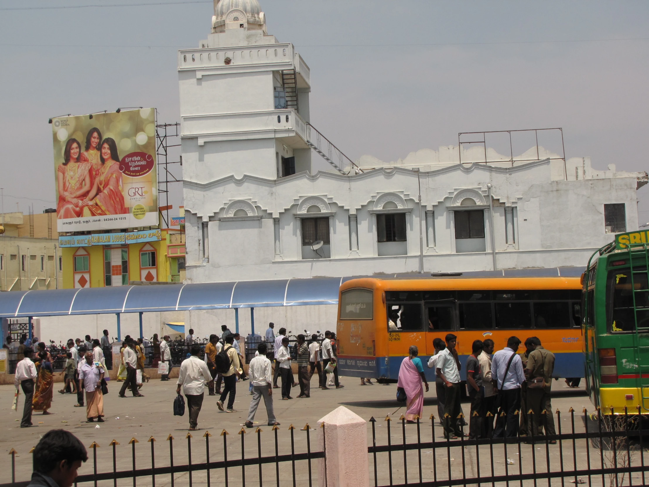 a yellow bus sits in front of a crowd of people