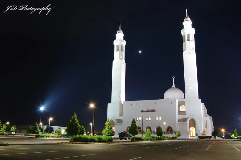 an islamic building with two large towers lit up in the night