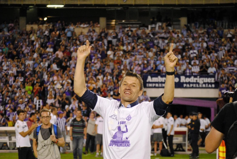 a man on a field waving at a crowd