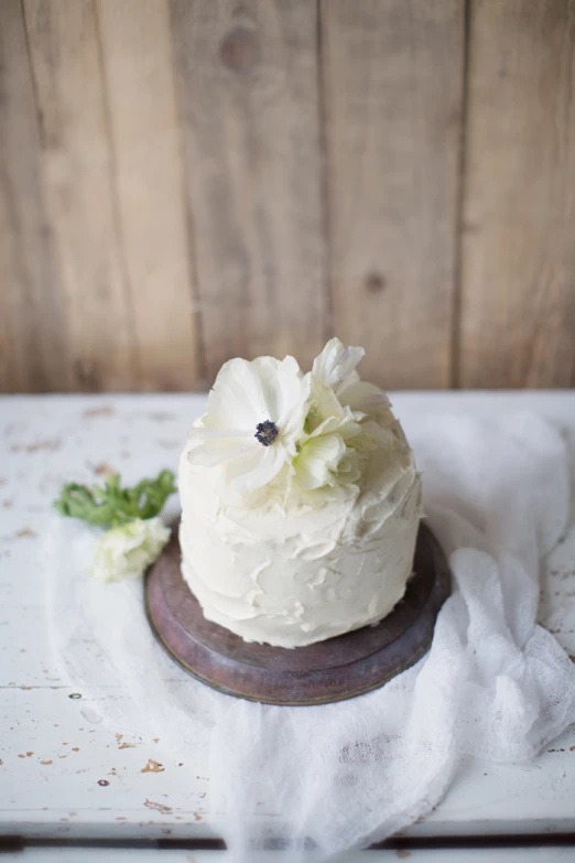 white frosted cake with flowers sitting on a table