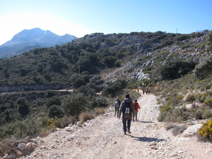 a group of people walking along a dirt road