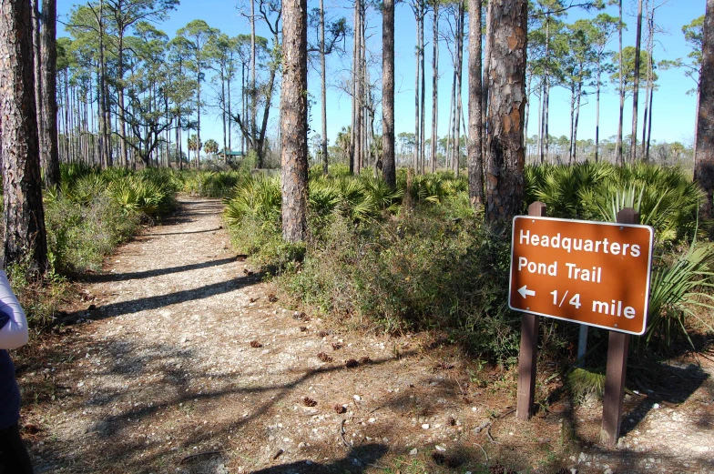 a sign that is on a dirt path