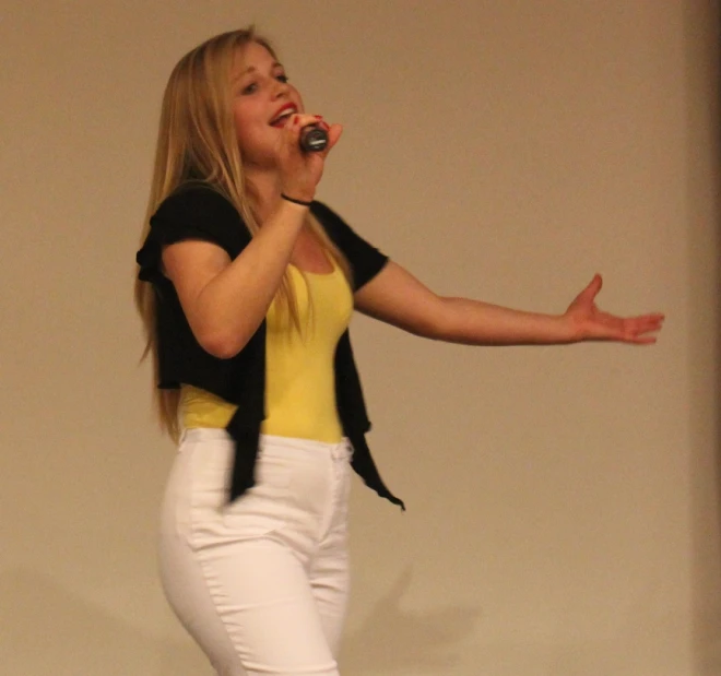 a woman is performing with a microphone at an event