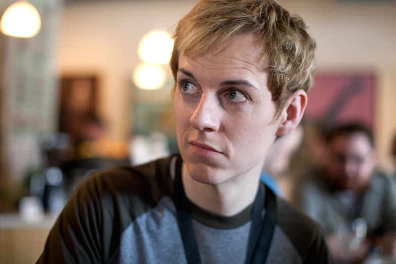 a man looking back as he sits in a restaurant