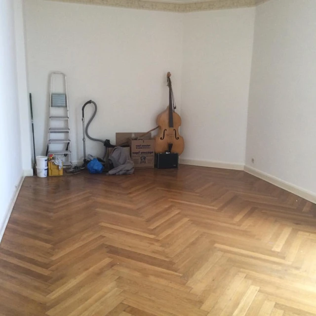 a room with a floor, a guitar and other items on it