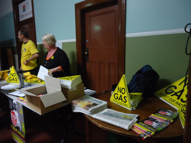 people stand in an office area lined up with books and posters