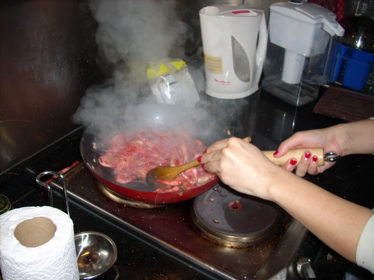 someone is stirring a pan of food on the stove