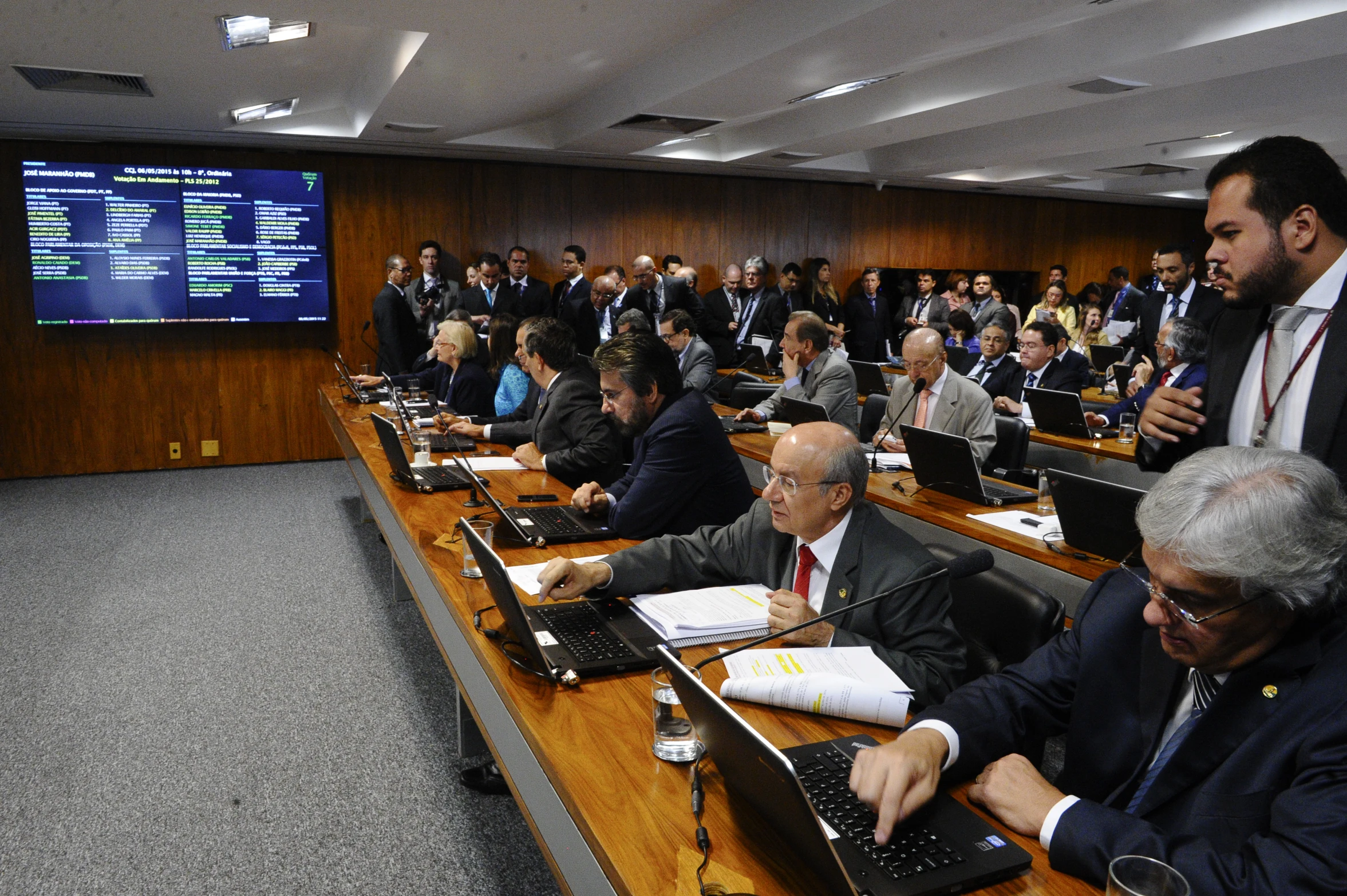 several people sitting at tables with laptop computers