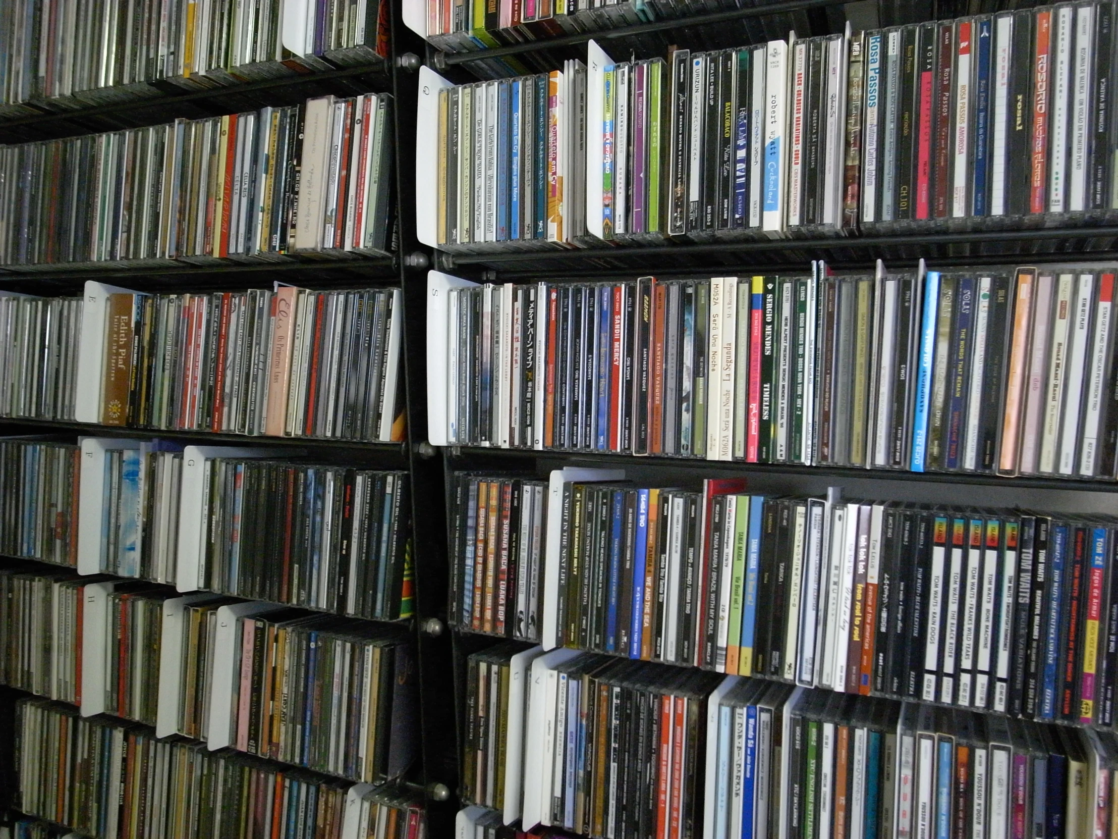 the rows of shelves have a lot of dvds on them