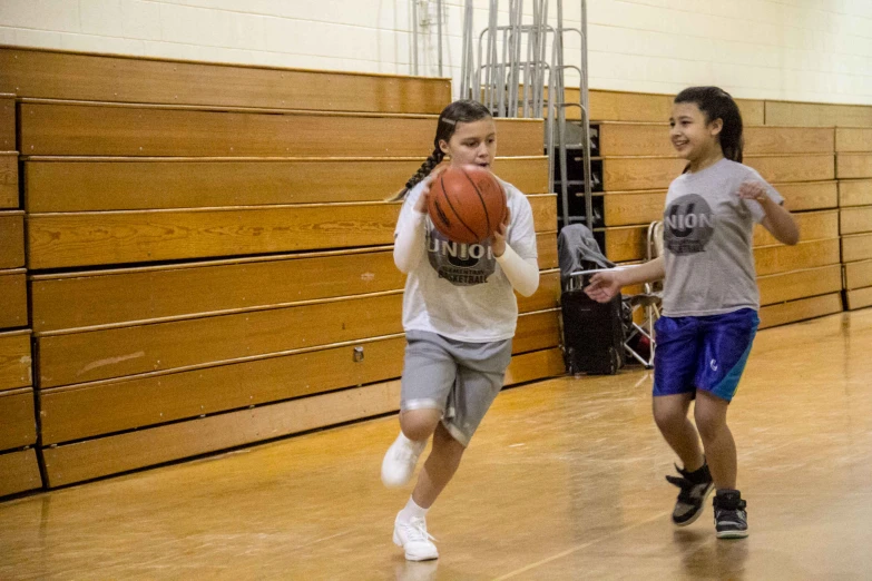 a man and woman playing basketball inside of a gym