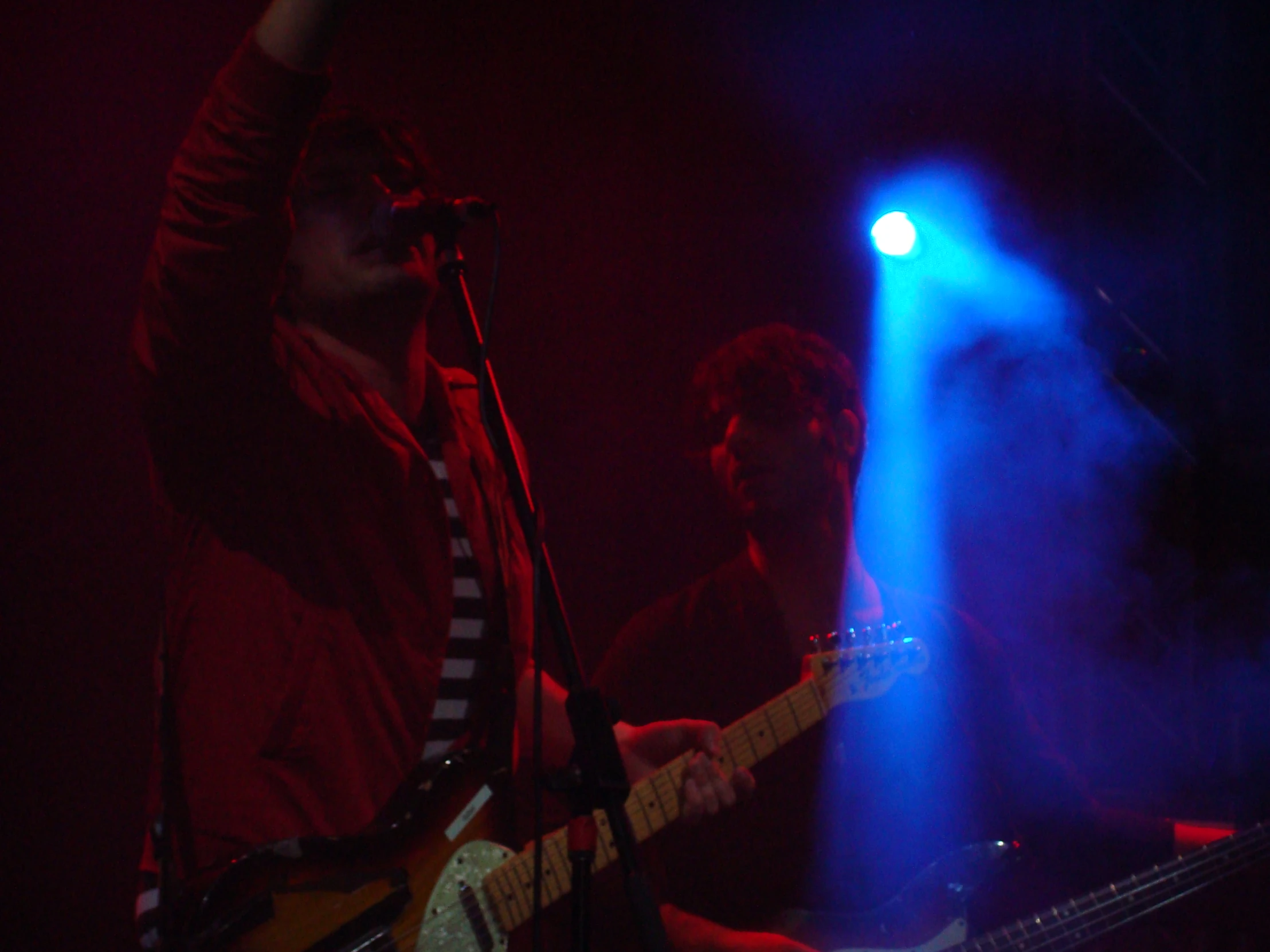 two men on stage holding onto guitars