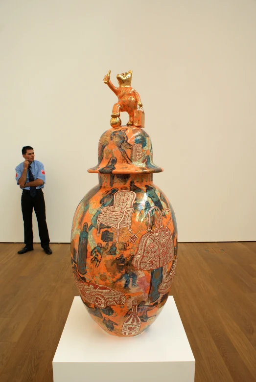an ornate vase with a gold statue of a man