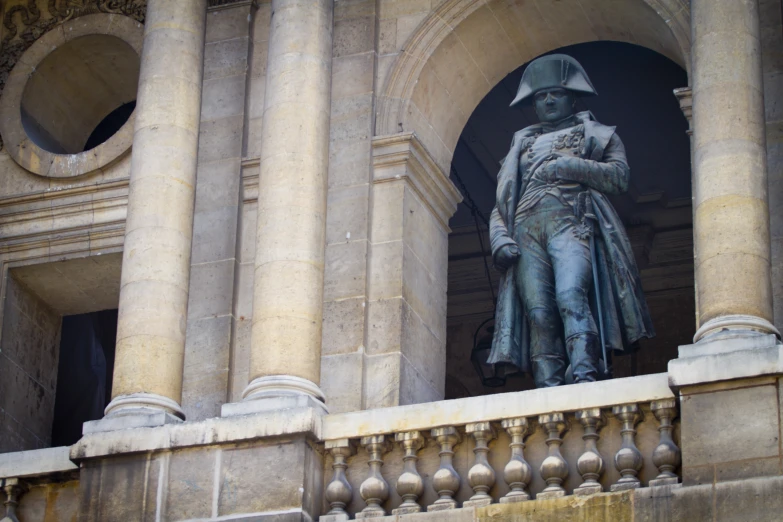 a statue of a man in full uniform is seen next to pillars