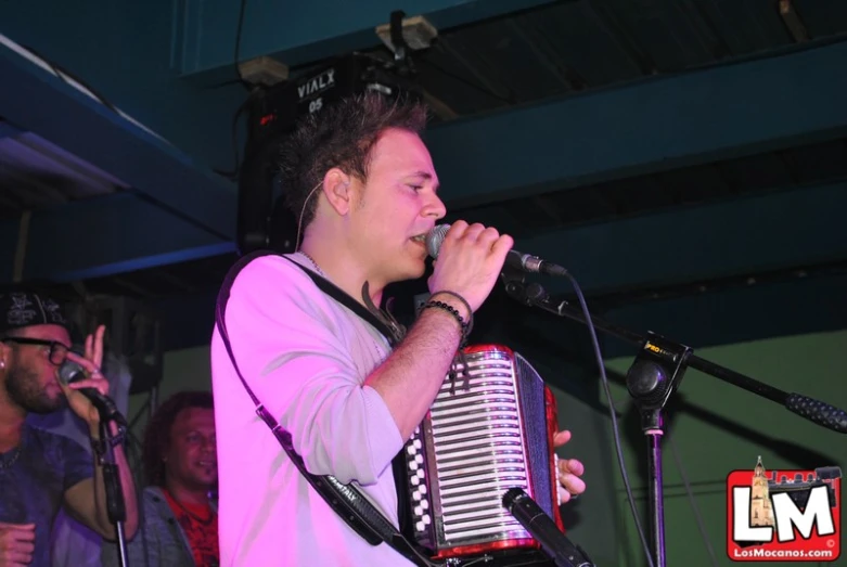 a musician is singing while his group watches