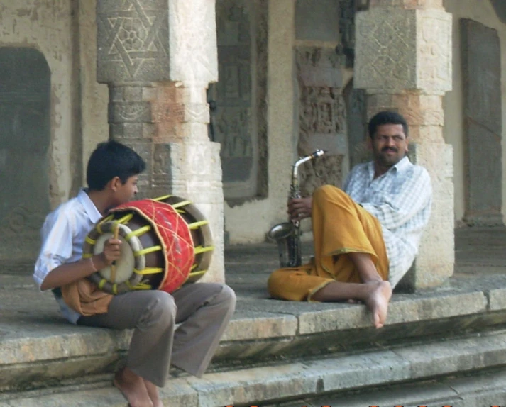 two men sitting on some steps with a band