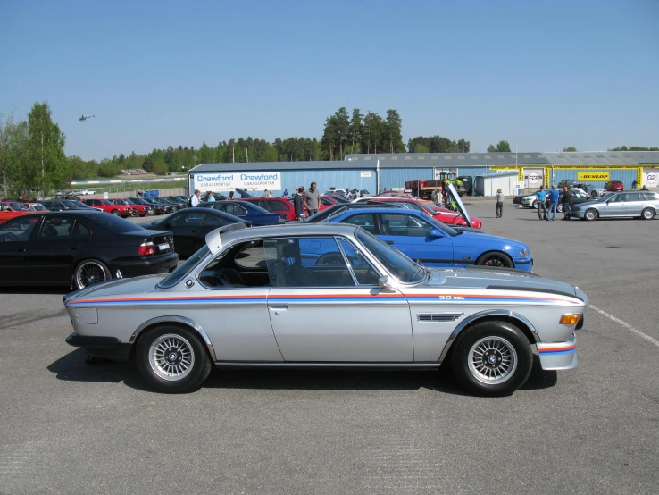 some cars are parked in the lot with people