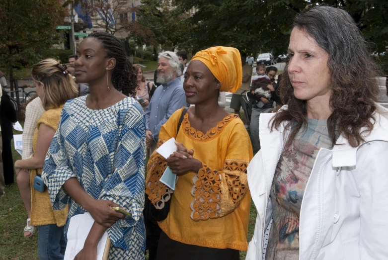 two women are standing outside near a crowd