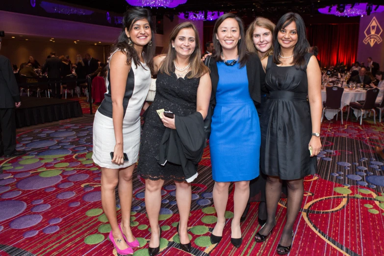 a group of girls standing on a red carpet together