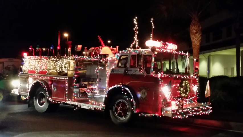 a fire truck decorated with christmas lights and decorations