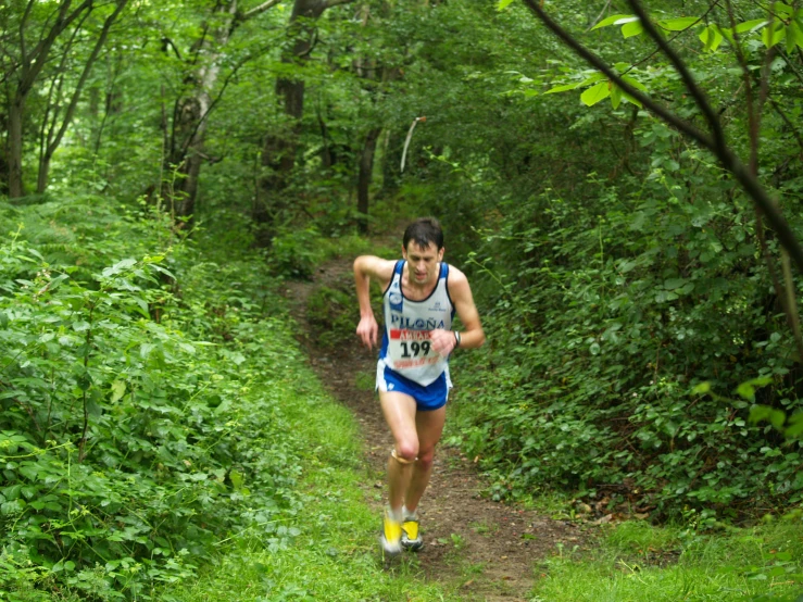 a man running on a trail through a forest
