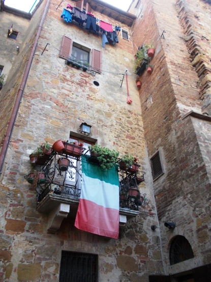 a balcony has an italian flag on the ledge