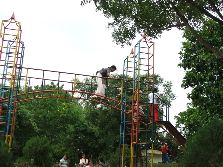 a man riding down a metal slide next to a forest