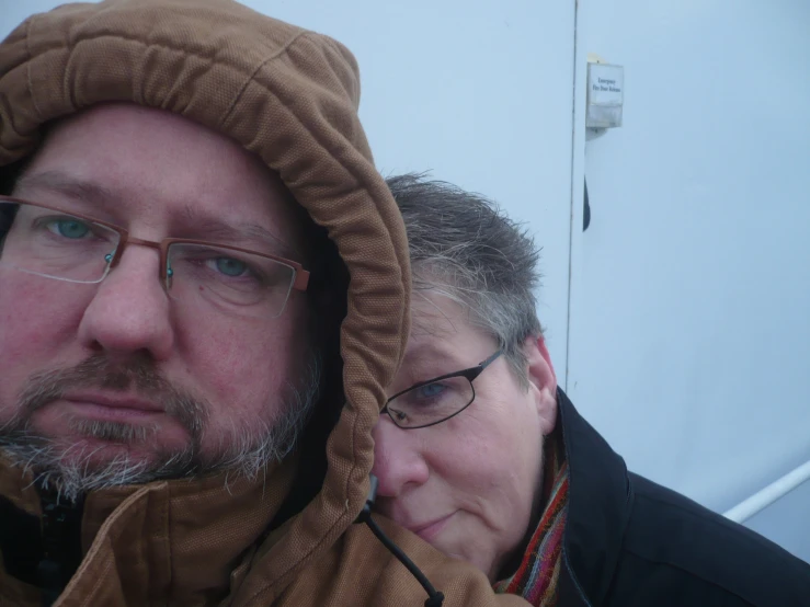 two people wearing glasses and warm clothing