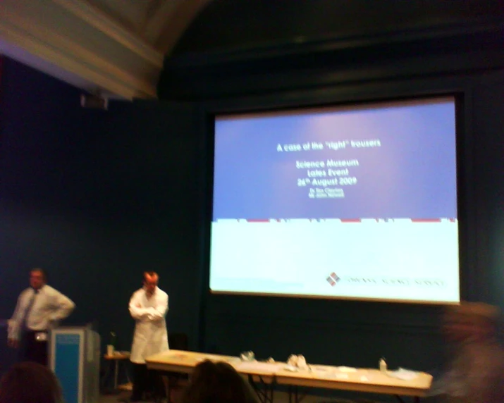 a man standing on stage presenting at a conference