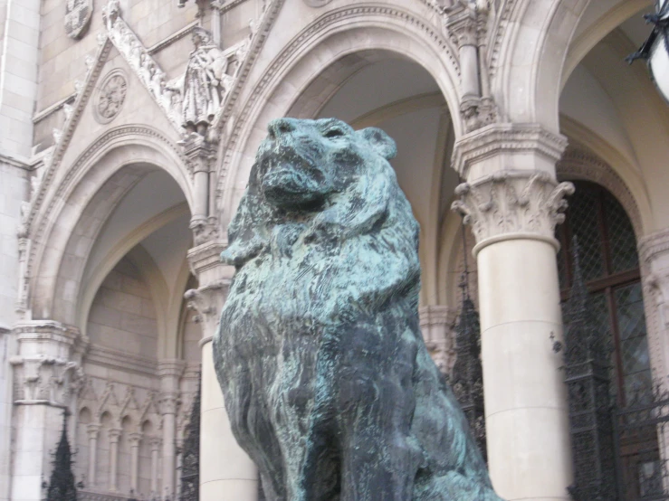 a bronze dog statue is in front of a tall building