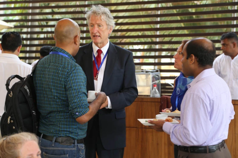 the man is talking with other men while having drinks