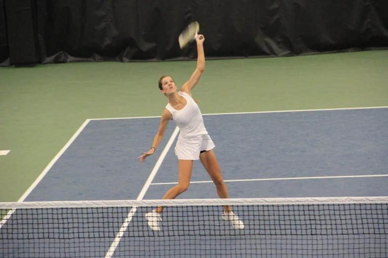 a woman standing on top of a tennis court holding a racquet