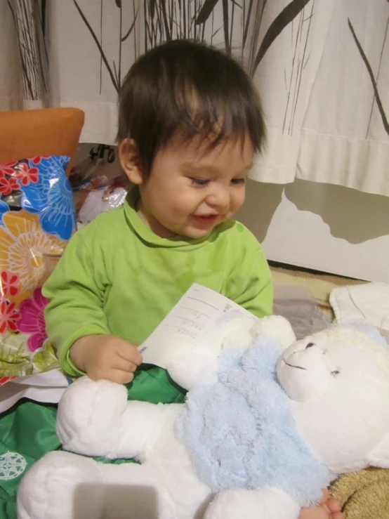 a toddler sitting in front of a stuffed animal