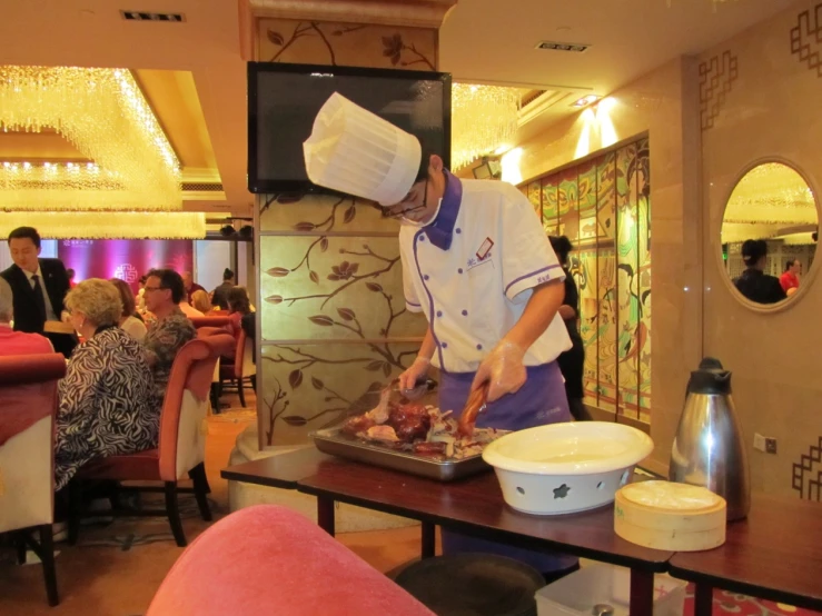 a man in chef's hat preparing food in a restaurant