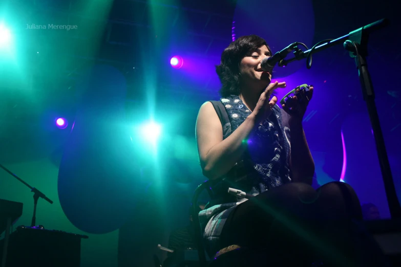 a woman is holding a microphone at a concert