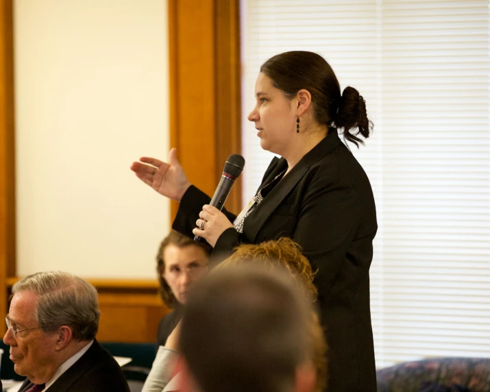 a woman standing next to a group of people talking