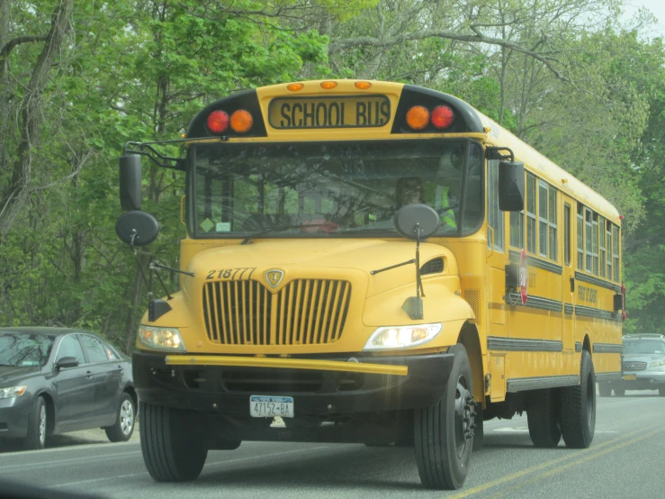 yellow school bus is driving down the street