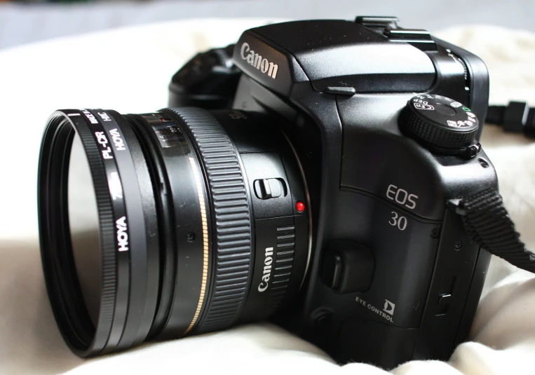 a camera on the bed is ready to be charged