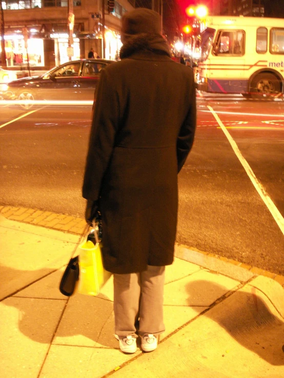 a man standing on a sidewalk while holding his bag