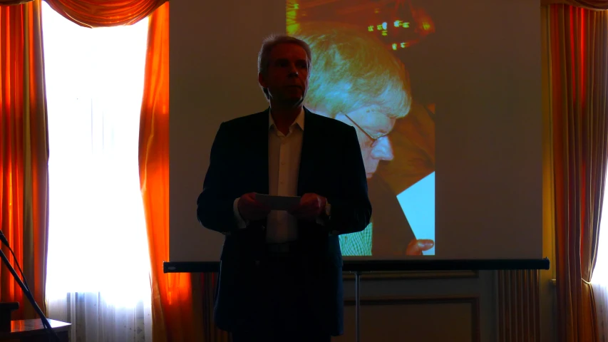 a man standing in front of a projection screen