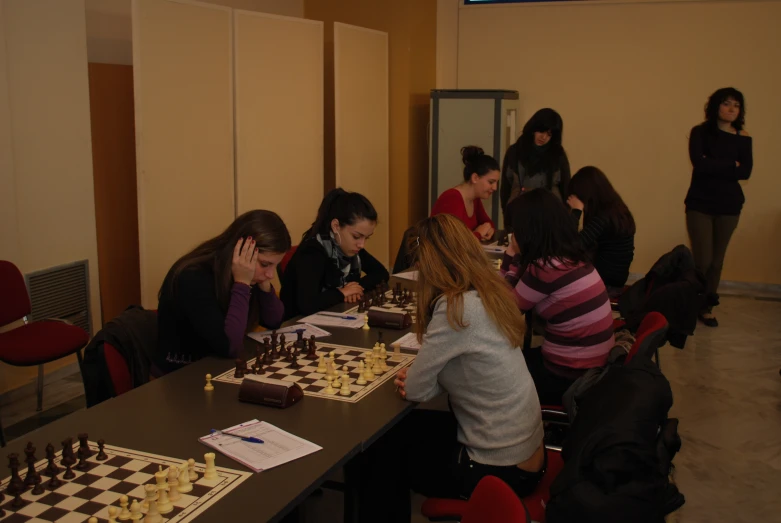 group of people playing chess in a room