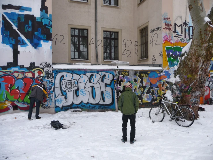 a man standing in the snow near a building