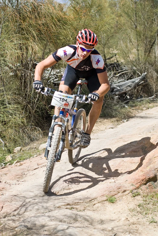 a man riding a bike up a dirt mountain