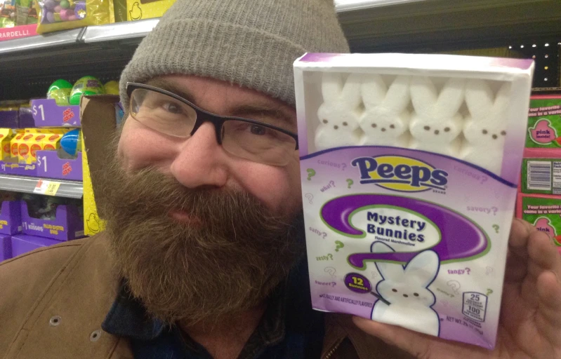 a bearded man holding up a box of eggs