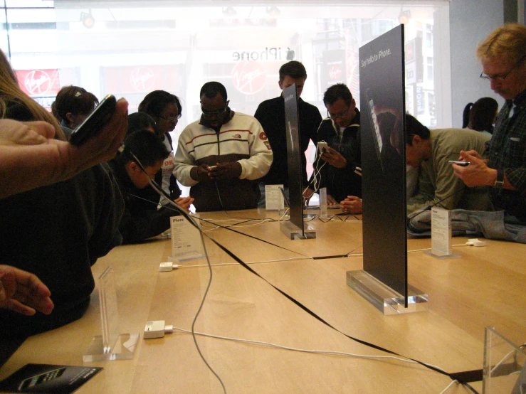 a group of people stand together to discuss their electronics