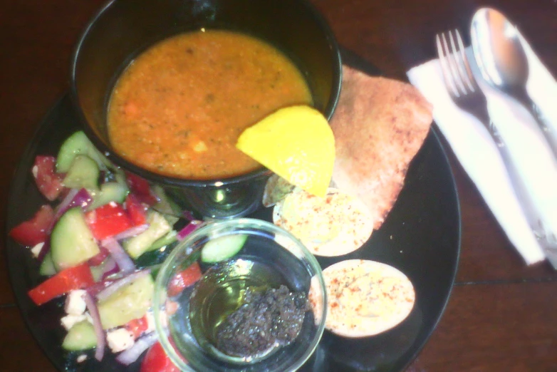 a bowl of soup with bread and salad on the side