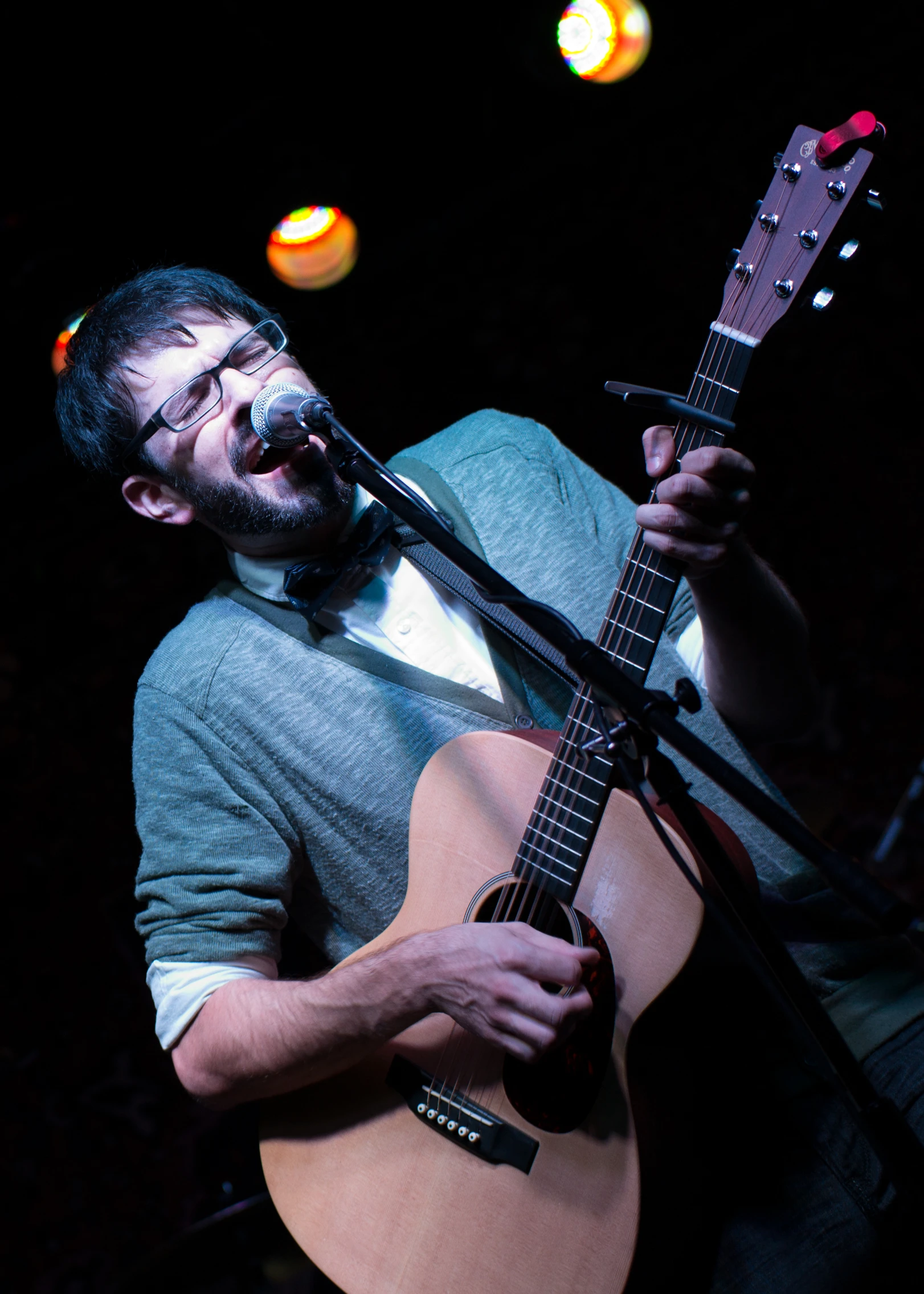 a man that is holding a guitar in his hand