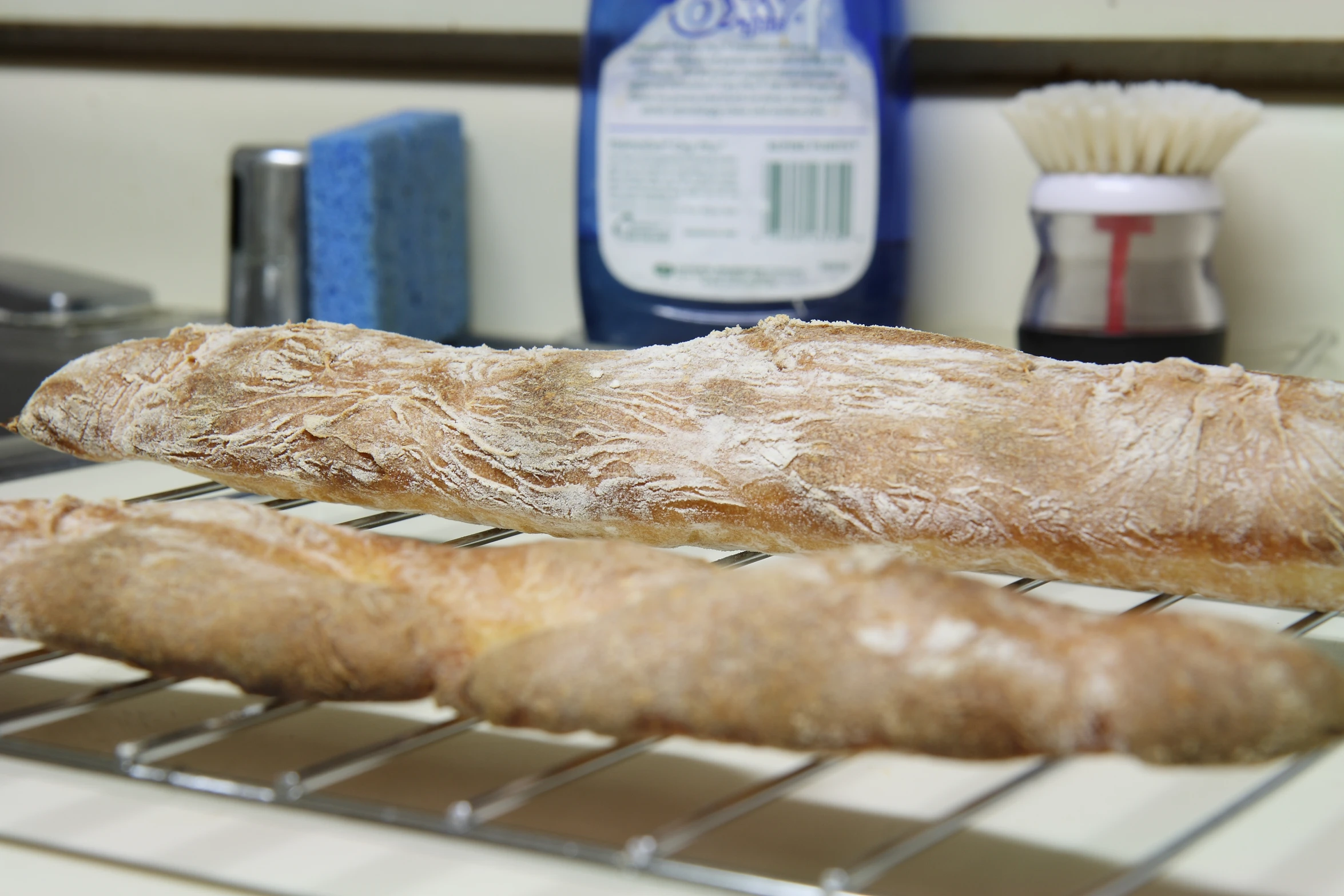 the long loaf of bread is cooling on the racks