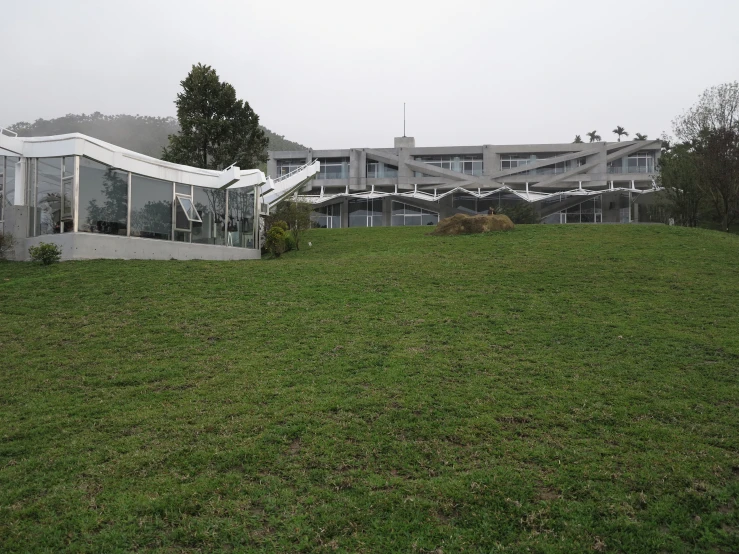 a building is near some grass on a cloudy day